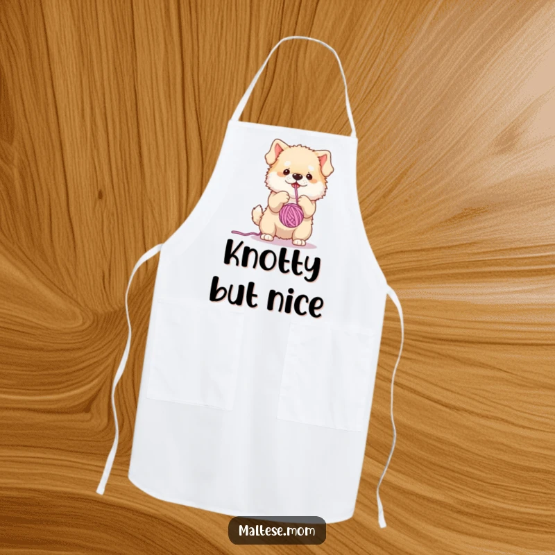 Funny apron showing a small, fluffy dog character hilariously occupied batting a dangling yarn ball, ideal for cooking fun.