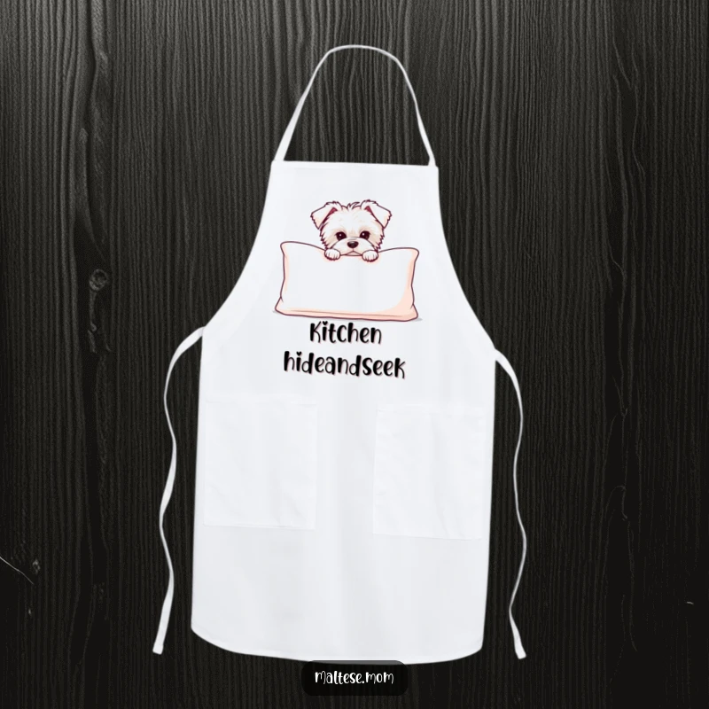 Funny Maltese puppy peeking from behind a large, soft cushion, on a practical apron for humorous kitchen use.