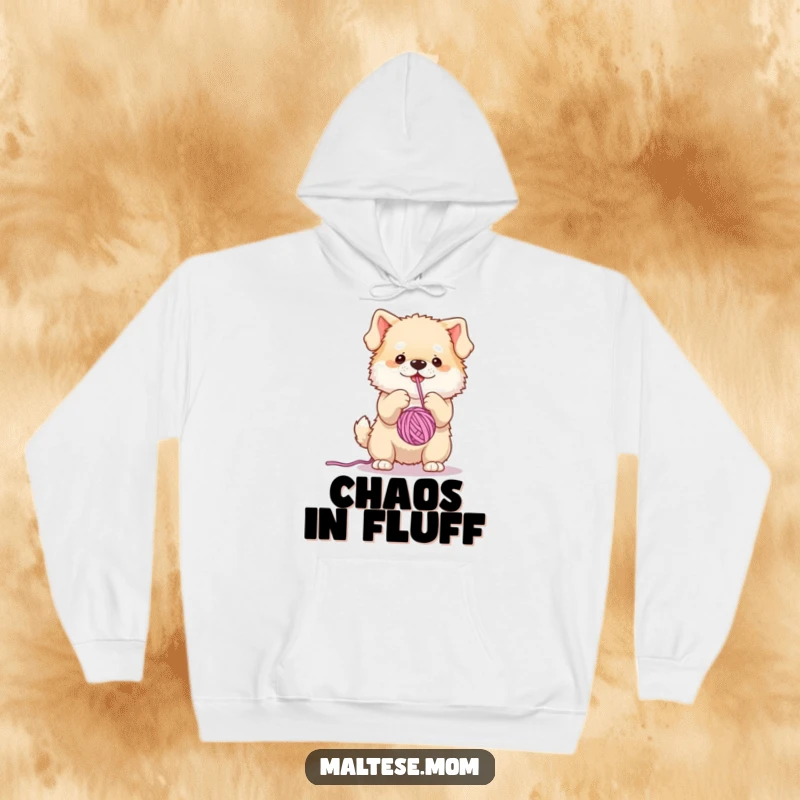 Funny, cozy hoodie depicting a fluffy dog character playfully attacking a dangling yarn ball, radiating infectious, energetic fun.