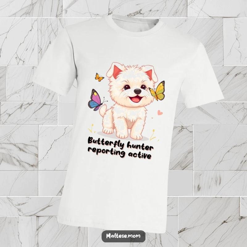Funny t-shirt showing a smiling Maltese puppy energetically chasing a fluttering butterfly, embodying playful joy and cuteness.