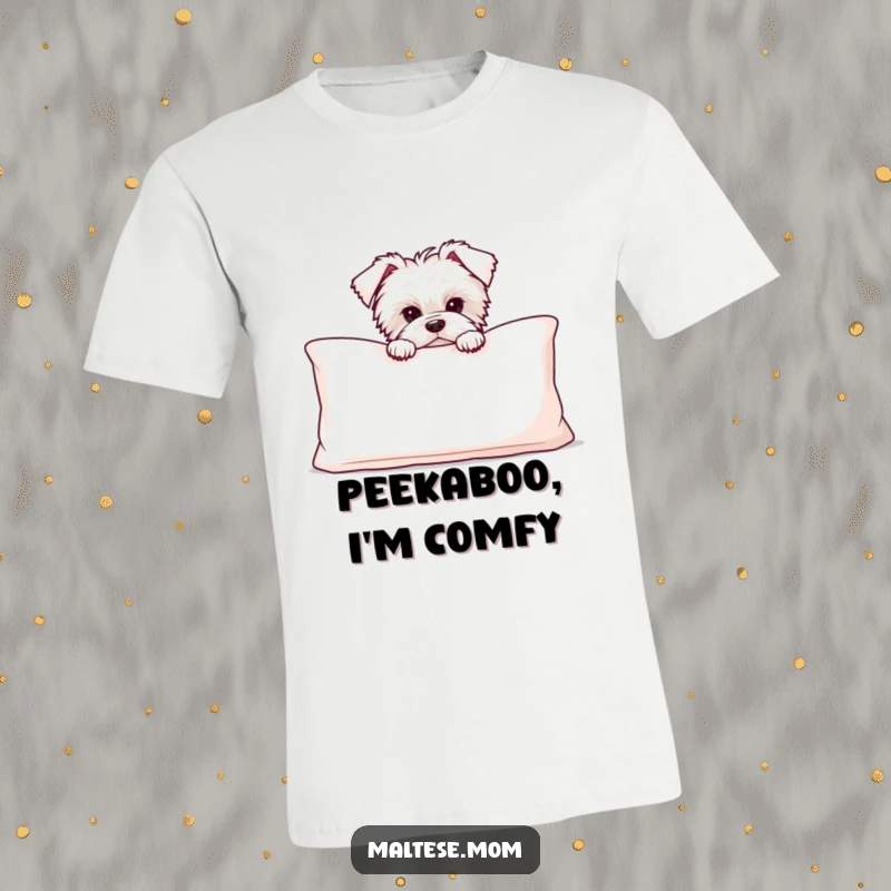 Funny Maltese puppy peeking shyly from behind a large, soft cushion on a comical t-shirt, inviting a game.