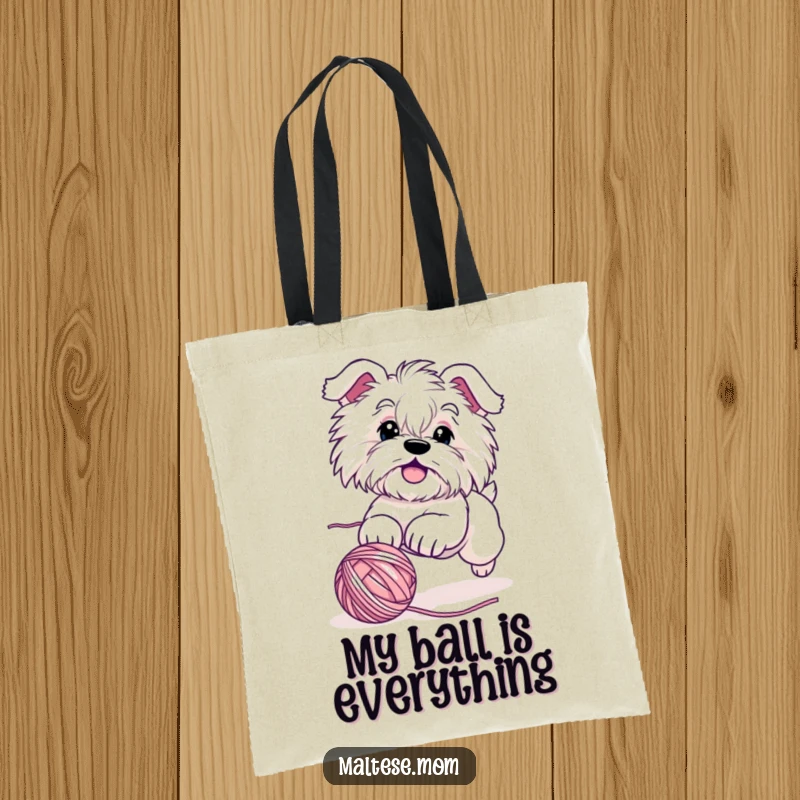 Funny Maltese dog tote bag depicting a cute, energetic character hilariously engaged in chasing a rolling ball of yarn, ideal for daily use.